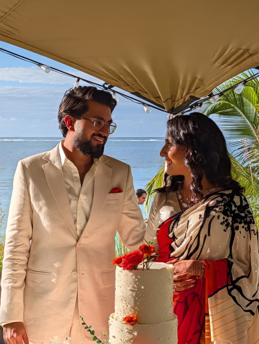 Keshav and Sanjna cutting the cake by the sea